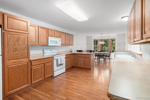 6144 Northridge Hills Dr, Brighton, MI 48116 - kitchen featuring white appliances, a peninsula, light countertops, light wood-style floors, and decorative light fixtures