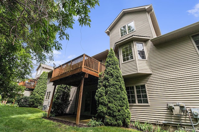 6144 Northridge Hills Dr, Brighton, MI 48116 - rear view of property featuring a lawn and a wooden deck