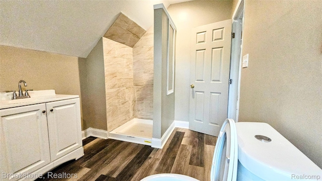 2520 Seyburn St, Detroit, MI 48214 - bathroom with wood finished floors, a tile shower, vanity, and lofted ceiling