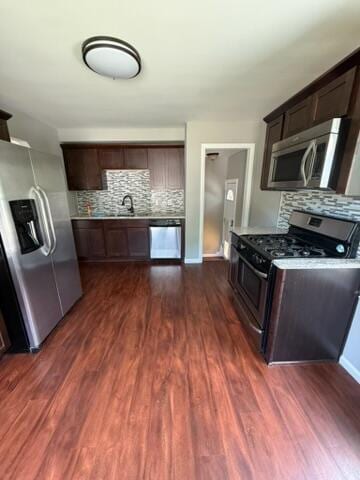 22026 Alger St, Saint Clair Shores, MI 48080 - kitchen with appliances with stainless steel finishes, tasteful backsplash, dark brown cabinetry, and dark wood-style flooring