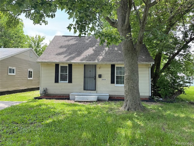 26439 Hopkins St, Dearborn, MI 48141 - cape cod house featuring a front yard and roof with shingles