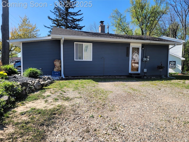 11329 E Shore Dr, Whitmore Lake, MI 48189 - rear view of house featuring a chimney and roof with shingles
