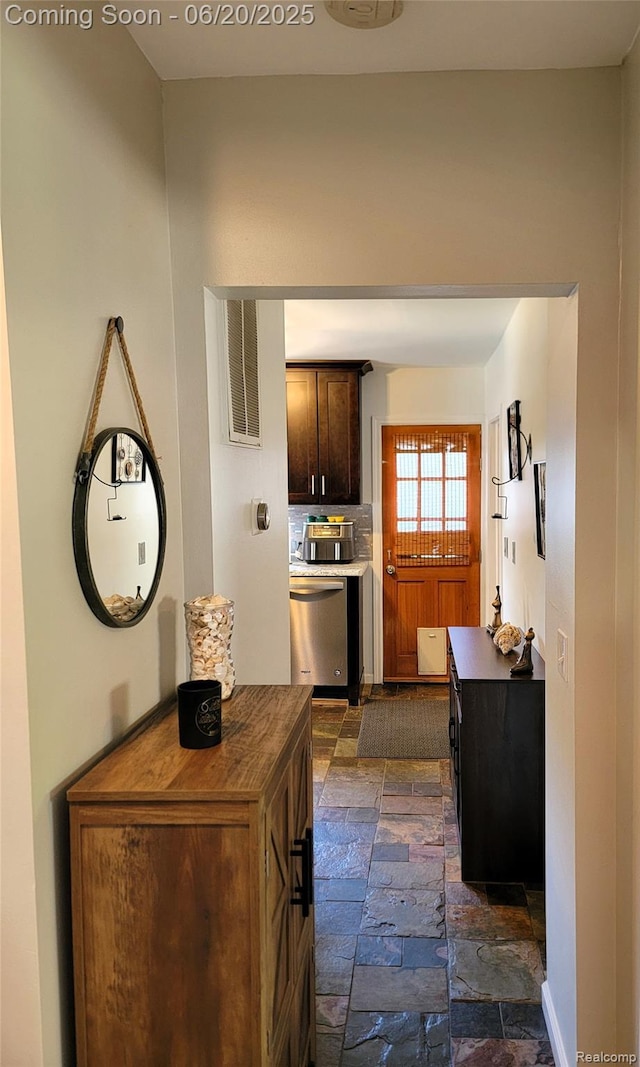 11329 E Shore Dr, Whitmore Lake, MI 48189 - kitchen with dishwasher, stone tile floors, dark brown cabinets, dark countertops, and decorative backsplash