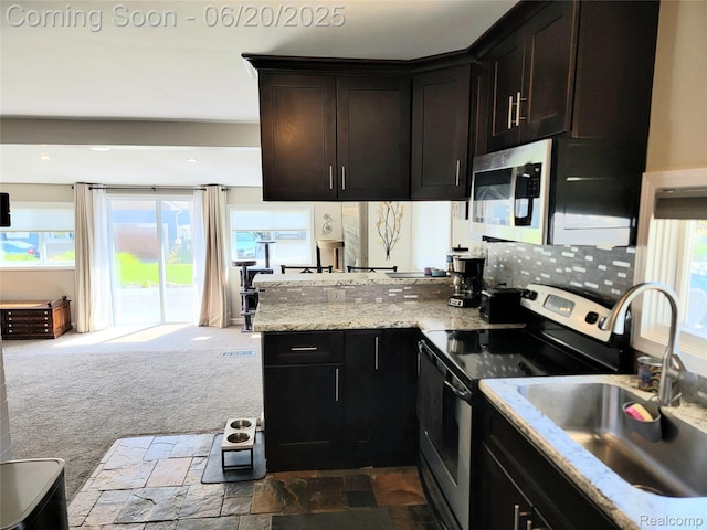 11329 E Shore Dr, Whitmore Lake, MI 48189 - kitchen with appliances with stainless steel finishes, a peninsula, light stone countertops, decorative backsplash, and recessed lighting