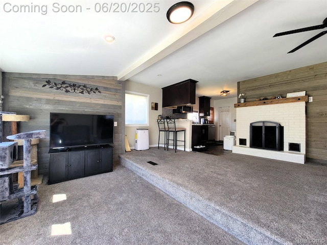 11329 E Shore Dr, Whitmore Lake, MI 48189 - living area with wood walls, dark carpet, ceiling fan, and a fireplace
