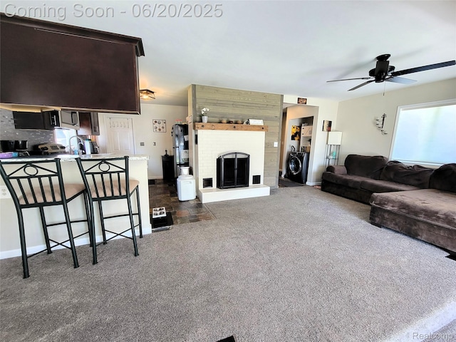 11329 E Shore Dr, Whitmore Lake, MI 48189 - living area featuring a ceiling fan, dark colored carpet, washer and dryer, and a fireplace