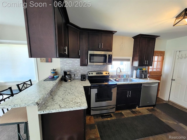 11329 E Shore Dr, Whitmore Lake, MI 48189 - kitchen with appliances with stainless steel finishes, backsplash, dark brown cabinets, dark wood-type flooring, and light stone counters