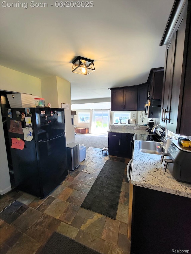 11329 E Shore Dr, Whitmore Lake, MI 48189 - kitchen with freestanding refrigerator, stone tile flooring, stainless steel microwave, and light stone counters