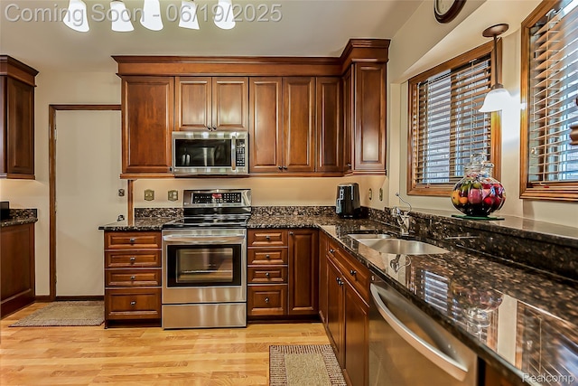 24320 Simmons Dr, Novi, MI 48374 - kitchen with appliances with stainless steel finishes, light wood-type flooring, dark stone counters, and healthy amount of natural light