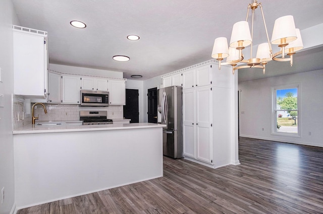 2502 Thorn Creek St SE, Kentwood, MI 49508 - kitchen with stainless steel appliances, dark wood-type flooring, light countertops, backsplash, and a peninsula