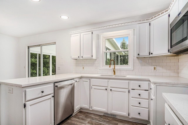 2502 Thorn Creek St SE, Kentwood, MI 49508 - kitchen with appliances with stainless steel finishes, a peninsula, white cabinetry, tasteful backsplash, and recessed lighting