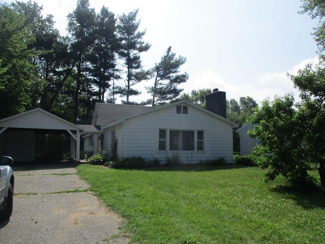 307 John St, Colon, MI 49040 - view of front of house with a chimney, a front lawn, driveway, and a carport