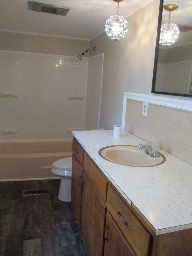 307 John St, Colon, MI 49040 - full bath featuring vanity, bathtub / shower combination, ornamental molding, wood finished floors, and backsplash