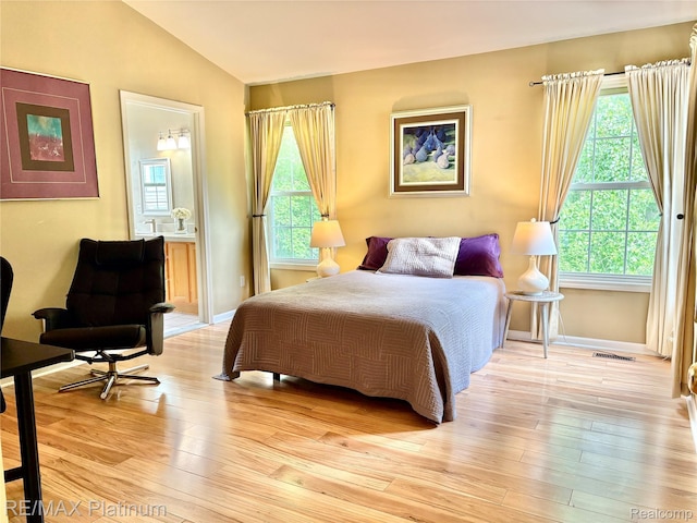 5089 Northfield Dr, Howell, MI 48843 - bedroom with lofted ceiling, light wood-type flooring, and ensuite bathroom