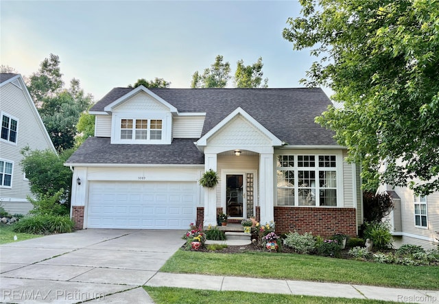 5089 Northfield Dr, Howell, MI 48843 - view of front of house featuring concrete driveway, brick siding, and roof with shingles