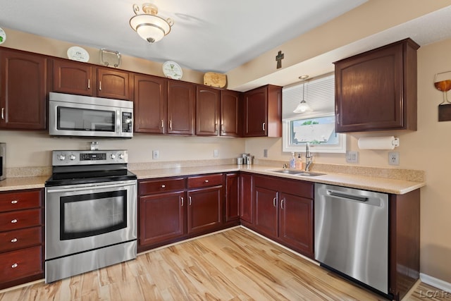 3564 Sapphire Dr, Adrian, MI 49221 - kitchen featuring appliances with stainless steel finishes, light countertops, light wood-type flooring, and reddish brown cabinets