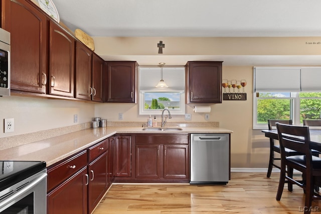 3564 Sapphire Dr, Adrian, MI 49221 - kitchen with stainless steel dishwasher, light wood finished floors, light countertops, and decorative light fixtures