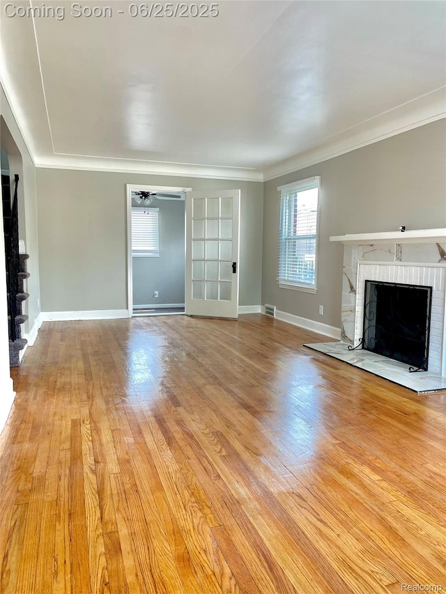 10351 Kramer, Detroit, MI 48204 - unfurnished living room with a brick fireplace, crown molding, plenty of natural light, and light wood finished floors