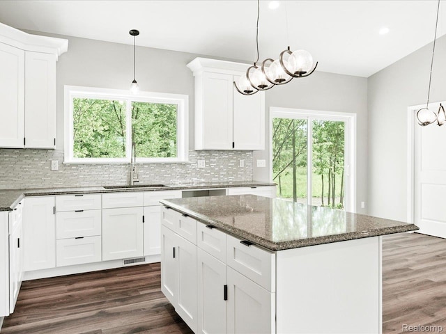 9711 Crawford, Columbus, MI 48063 - kitchen with a chandelier, tasteful backsplash, dark stone counters, dark wood finished floors, and a kitchen island