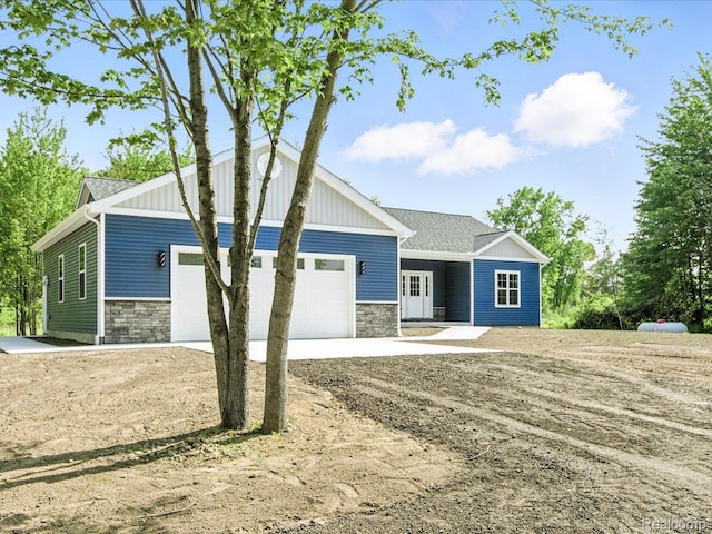 9711 Crawford, Columbus, MI 48063 - view of front of property featuring stone siding, a garage, concrete driveway, and board and batten siding