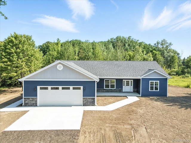 9711 Crawford, Columbus, MI 48063 - ranch-style home featuring stone siding, concrete driveway, an attached garage, french doors, and a shingled roof