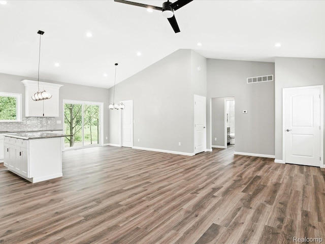 9711 Crawford, Columbus, MI 48063 - unfurnished living room featuring a ceiling fan, high vaulted ceiling, recessed lighting, wood finished floors, and a chandelier