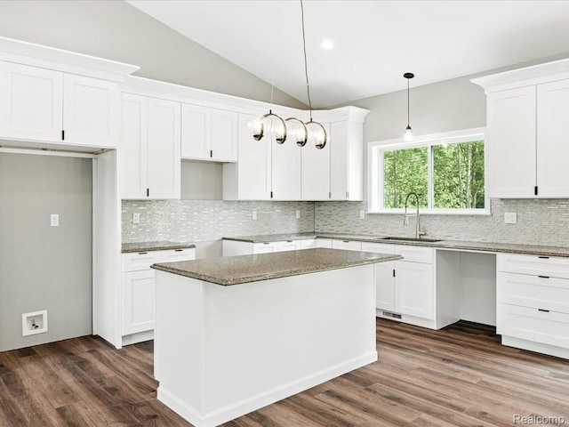 9711 Crawford, Columbus, MI 48063 - kitchen featuring backsplash, vaulted ceiling, dark wood-type flooring, white cabinets, and hanging light fixtures