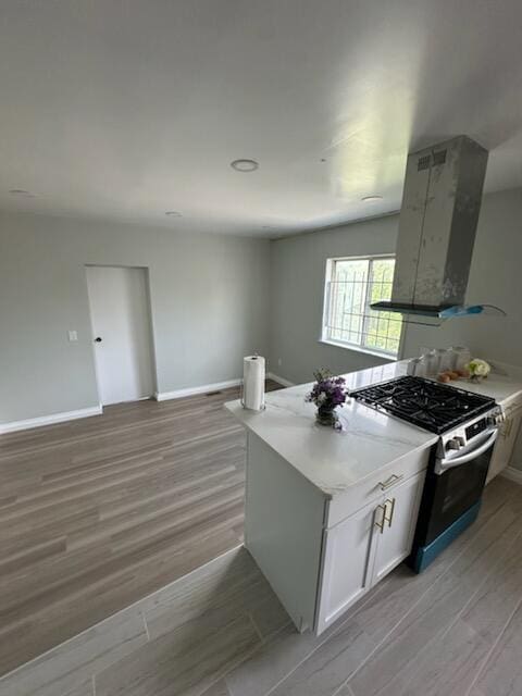 3550 Burns St, Inkster, MI 48141 - kitchen featuring stainless steel range with gas stovetop, ventilation hood, light wood-style flooring, white cabinetry, and open floor plan