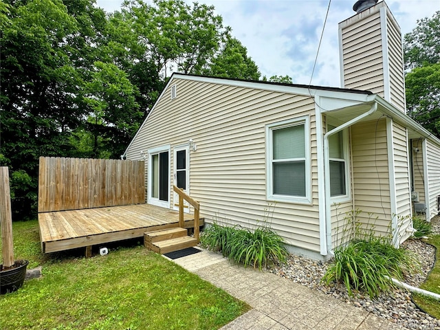 7841 Horseshoe Creek Ct, Whitmore Lake, MI 48189 - rear view of house featuring a chimney, a deck, and a lawn