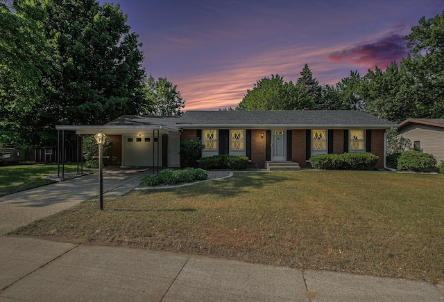 1136 3 Mile Rd NW, Grand Rapids, MI 49544 - ranch-style house featuring concrete driveway, brick siding, a garage, and a lawn