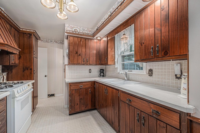 1136 3 Mile Rd NW, Grand Rapids, MI 49544 - kitchen featuring white electric stove, backsplash, light tile patterned floors, light countertops, and ventilation hood