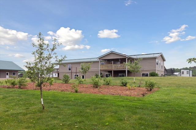 21576 220th Ave, Tustin, MI 49688 - rear view of house with a standing seam roof, a lawn, a metal roof, and a deck
