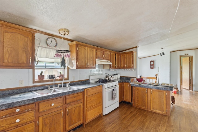 21576 220th Ave, Tustin, MI 49688 - kitchen featuring white gas range oven, under cabinet range hood, brown cabinets, a textured ceiling, and dark countertops