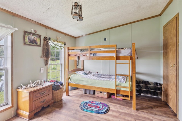 21576 220th Ave, Tustin, MI 49688 - bedroom with crown molding, multiple windows, a textured ceiling, and wood finished floors