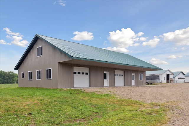 21576 220th Ave, Tustin, MI 49688 - view of property exterior with a garage, an outbuilding, a yard, and a metal roof
