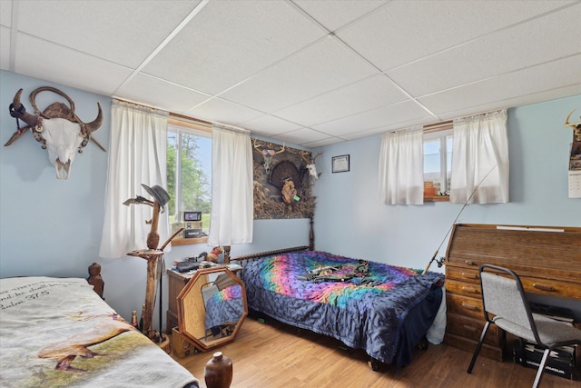 21576 220th Ave, Tustin, MI 49688 - bedroom featuring a drop ceiling, wood finished floors, and multiple windows