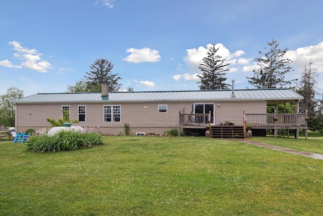 21576 220th Ave, Tustin, MI 49688 - back of property featuring a deck, a yard, a standing seam roof, and a metal roof