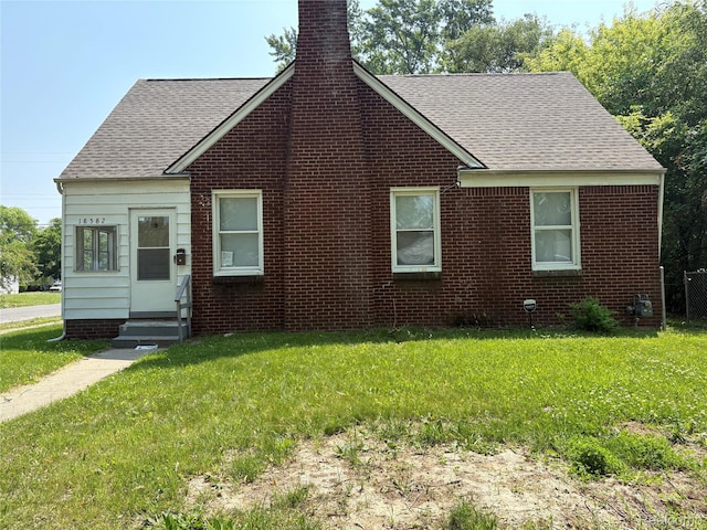 18582 Edinborough Rd, Detroit, MI 48219 - view of front of home featuring a chimney, roof with shingles, entry steps, and a front lawn