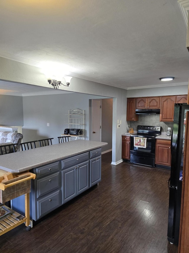28548 Fairlane Dr, Dowagiac, MI 49047 - kitchen with black appliances, under cabinet range hood, light countertops, dark wood-type flooring, and crown molding