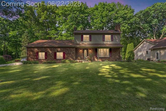13256 Pine Valley Dr, Clio, MI 48420 - traditional home with a chimney, a front yard, and brick siding
