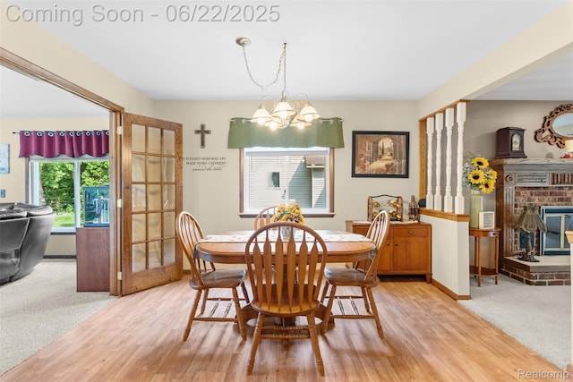 13256 Pine Valley Dr, Clio, MI 48420 - dining room featuring a chandelier, wood finished floors, and a brick fireplace