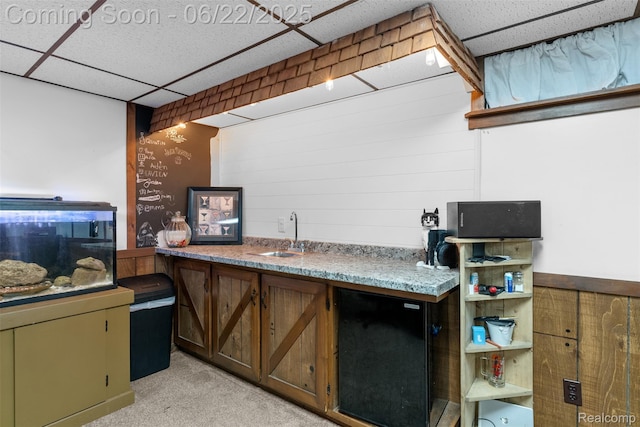 13256 Pine Valley Dr, Clio, MI 48420 - kitchen with a paneled ceiling, fridge, light carpet, and wooden walls