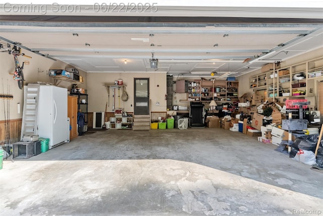 13256 Pine Valley Dr, Clio, MI 48420 - garage with freestanding refrigerator and a garage door opener