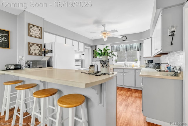 727 Minnie St, Port Huron, MI 48060 - kitchen with white appliances, a peninsula, ceiling fan, light wood-type flooring, and light countertops