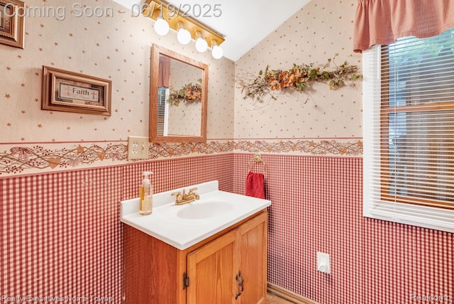 727 Minnie St, Port Huron, MI 48060 - bathroom with wallpapered walls, vanity, vaulted ceiling, and a wainscoted wall