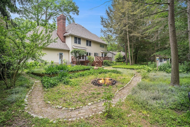 4686 Doug Dr, Whitehall, MI 49461 - back of house featuring a fire pit, a chimney, a deck, and a shed