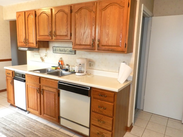 2865 Carrie Ln, Saint Joseph, MI 49085 - kitchen with white dishwasher, light tile patterned flooring, light countertops, and brown cabinetry