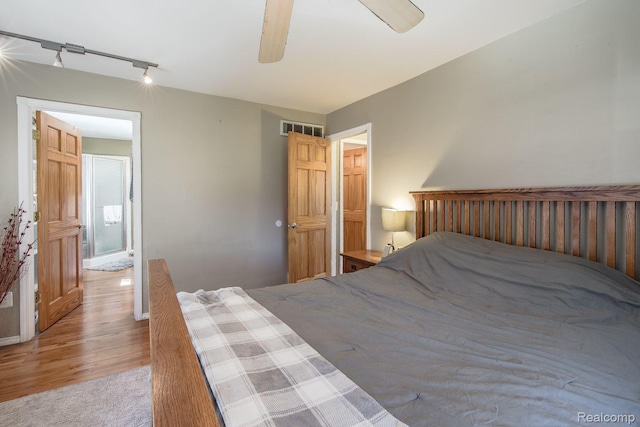 12109 Shaffer Rd, Davisburg, MI 48350 - carpeted bedroom with track lighting, wood finished floors, and a ceiling fan