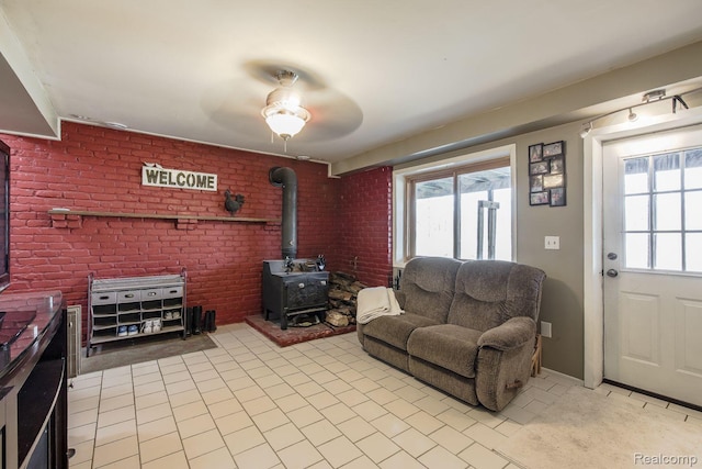 12109 Shaffer Rd, Davisburg, MI 48350 - living area with a wood stove, healthy amount of natural light, ceiling fan, and light tile patterned flooring
