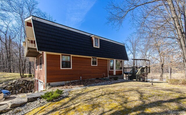 12109 Shaffer Rd, Davisburg, MI 48350 - back of house featuring a deck, mansard roof, stairway, and a lawn
